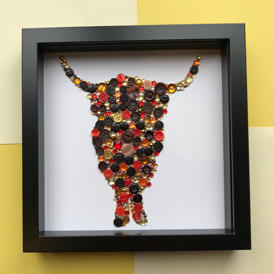 gold and bronze highland cow button art on white. framed picture